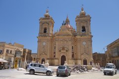 Městečko Ix-Xaghra. Mají tady nejstarší maltský chrám Ggantija. Věrka je ale naštěstí podobný kulturní barbar jako já, a tak jsme se na chrám vykašlali a šli na náměstí na pivo:-) ...  počkat, než si Věrčina spolubydlící ty 5500 let staré šutry na poli prohlédne :-)